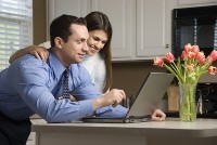 Young man and woman looking at websites on a laptop computer.